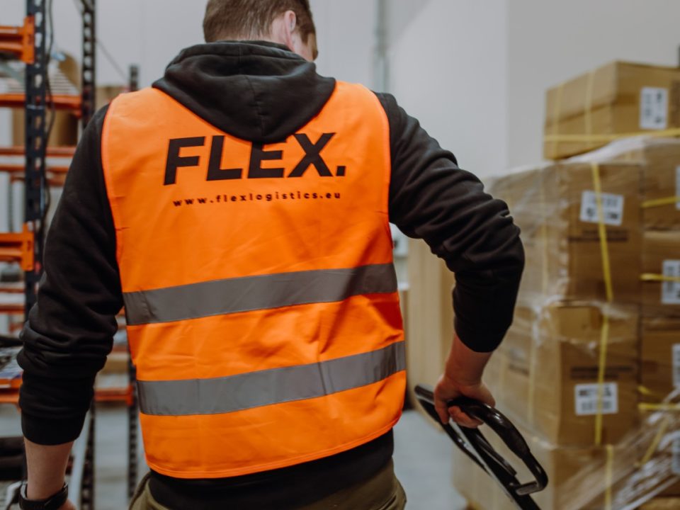 Flex employee pushing a cart through a warehouse