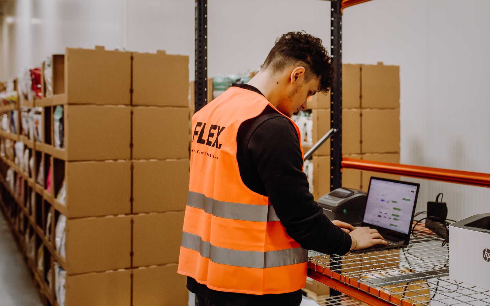 FLEX warehouse worker checking inventory on a computer