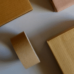 Brown cardboard boxes and a roll of packing tape are arranged on a light gray surface. The scene conveys a sense of organization and preparedness.
