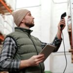 Warehouse worker scanning parcels in a modern fulfillment hub.