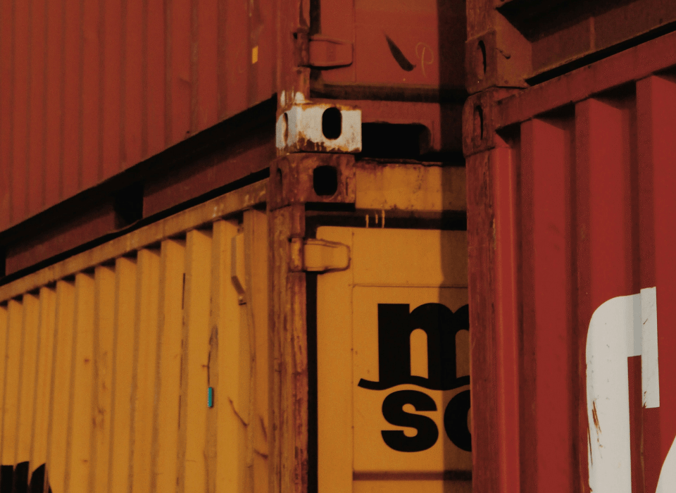 Stack of red and yellow shipping containers representing cross-border customs checks and import-export procedures in European dropshipping.
