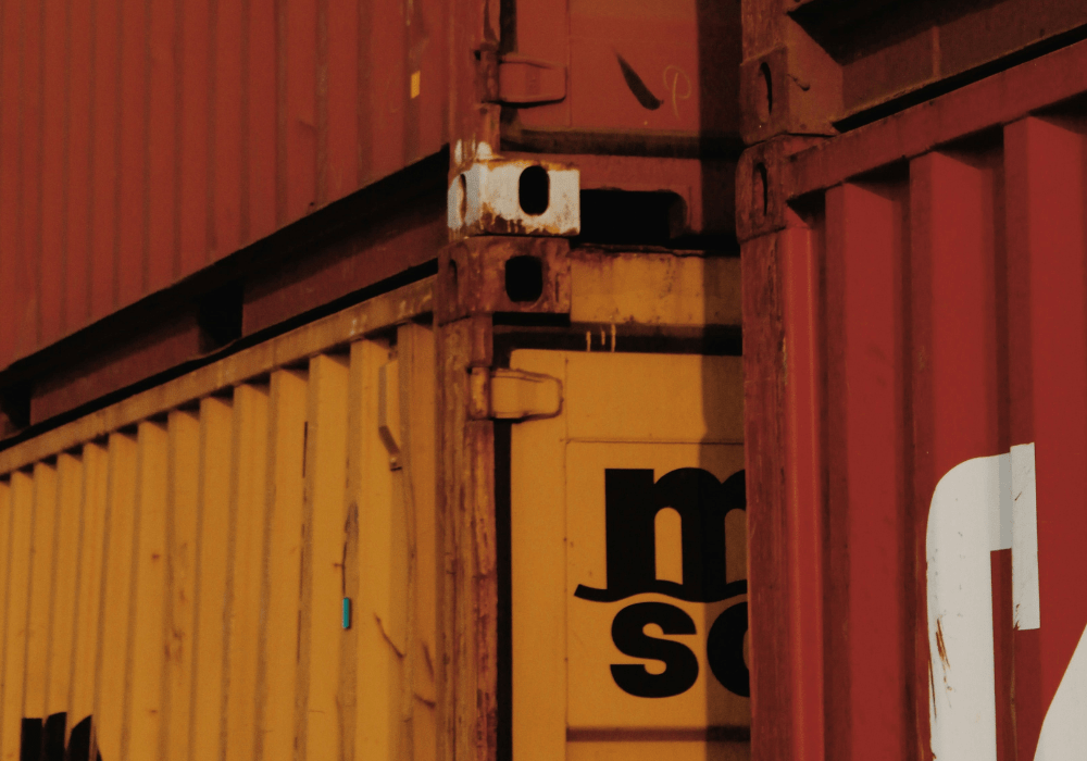 Stack of red and yellow shipping containers representing cross-border customs checks and import-export procedures in European dropshipping.