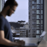 Entrepreneur managing multi-channel dropshipping operations on a laptop, with a city skyline in the background, representing remote e-commerce management across Amazon, Shopify and European marketplaces.
