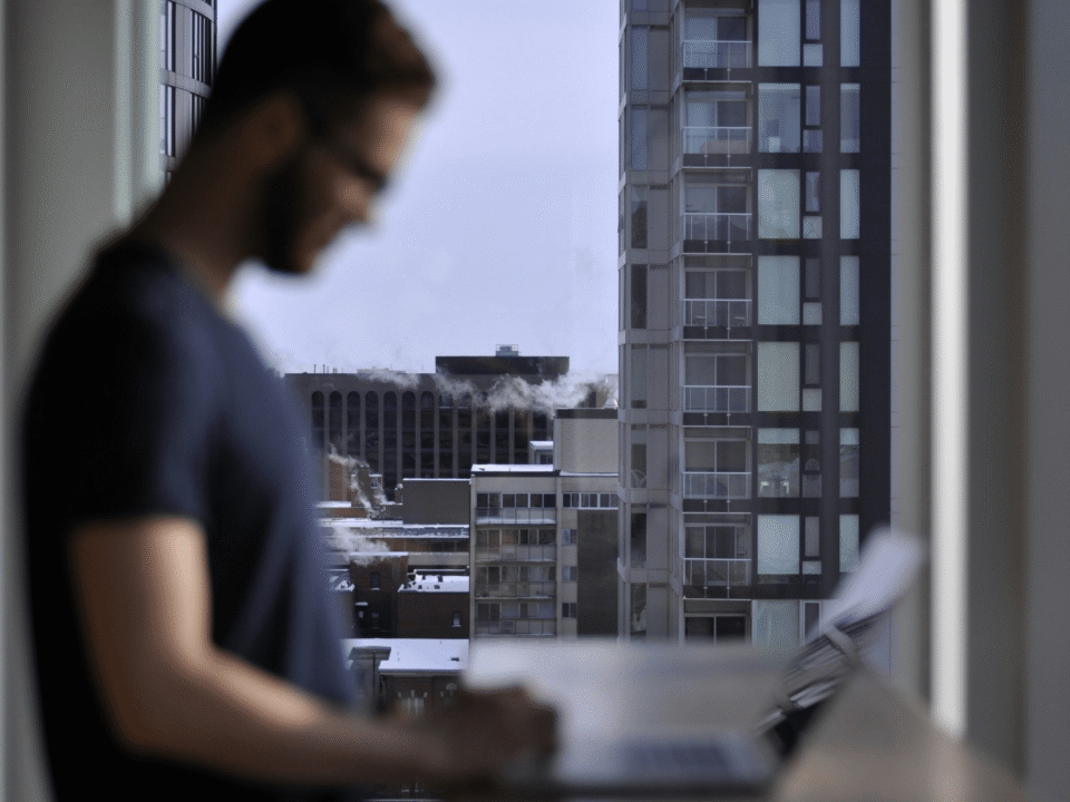 Entrepreneur managing multi-channel dropshipping operations on a laptop, with a city skyline in the background, representing remote e-commerce management across Amazon, Shopify and European marketplaces.