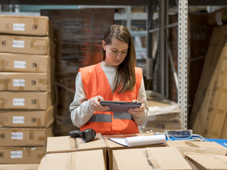 Warehouse worker inside of a modern fulfillment center among shelves stacked with parcels.