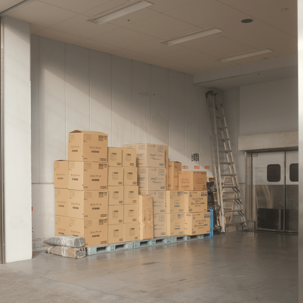 Stacked cardboard boxes awaiting processing in a warehouse loading area, illustrating the importance of organized inventory.