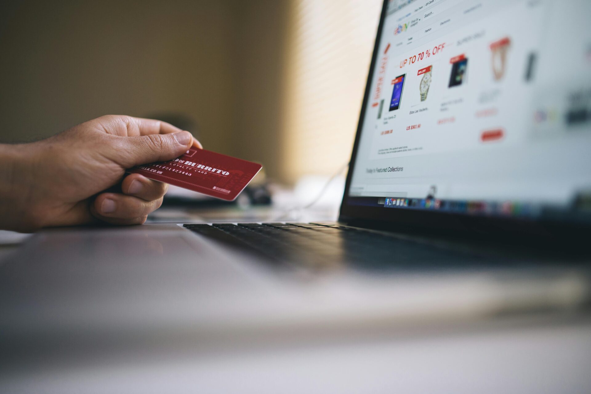 Close-up of a customer in front of his computer screen making a payment for online shopping.
