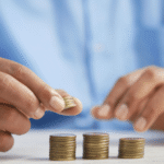 Hands stacking coins to symbolize the financial impact of VAT, duties and customs compliance, illustrating how smart fulfillment helps brands manage costs across EU markets.