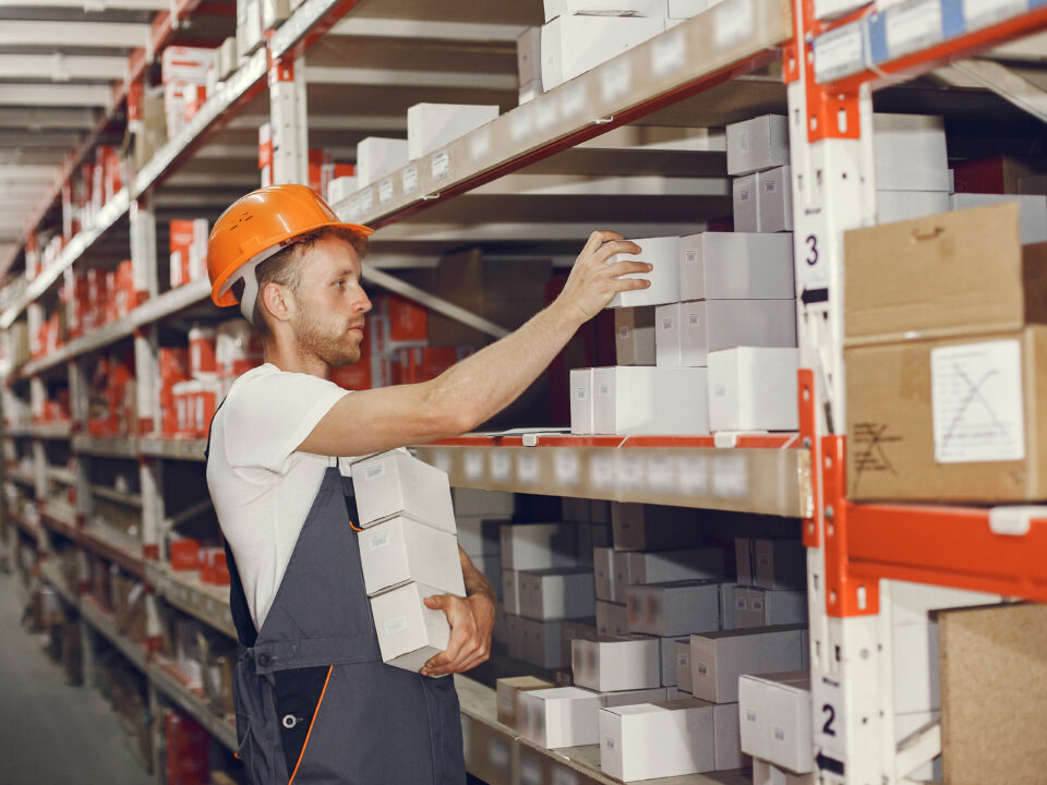 Warehouse worker restocking shelves to prepare for peak season order volume.