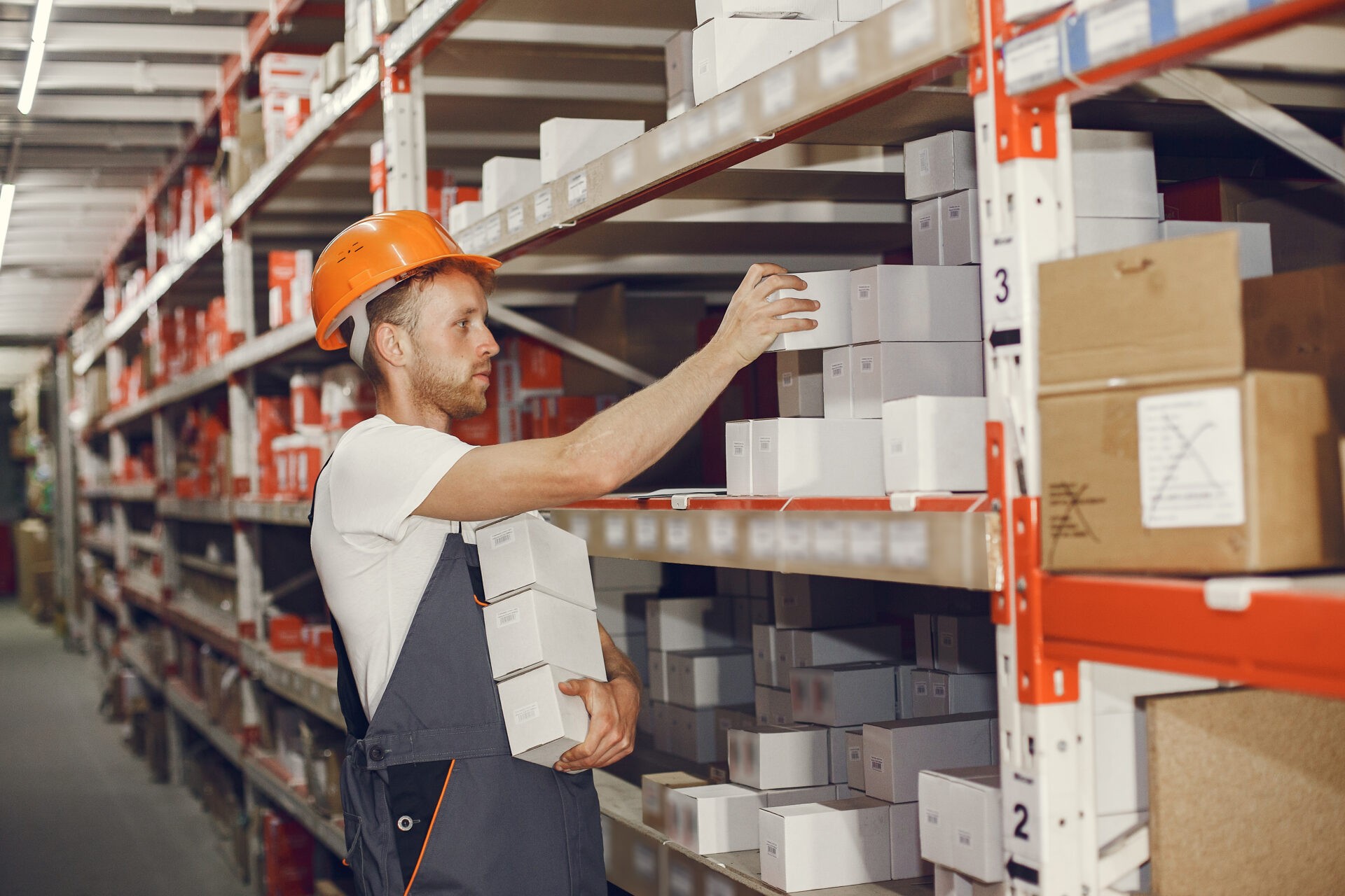 Warehouse worker restocking shelves to prepare for peak season order volume.