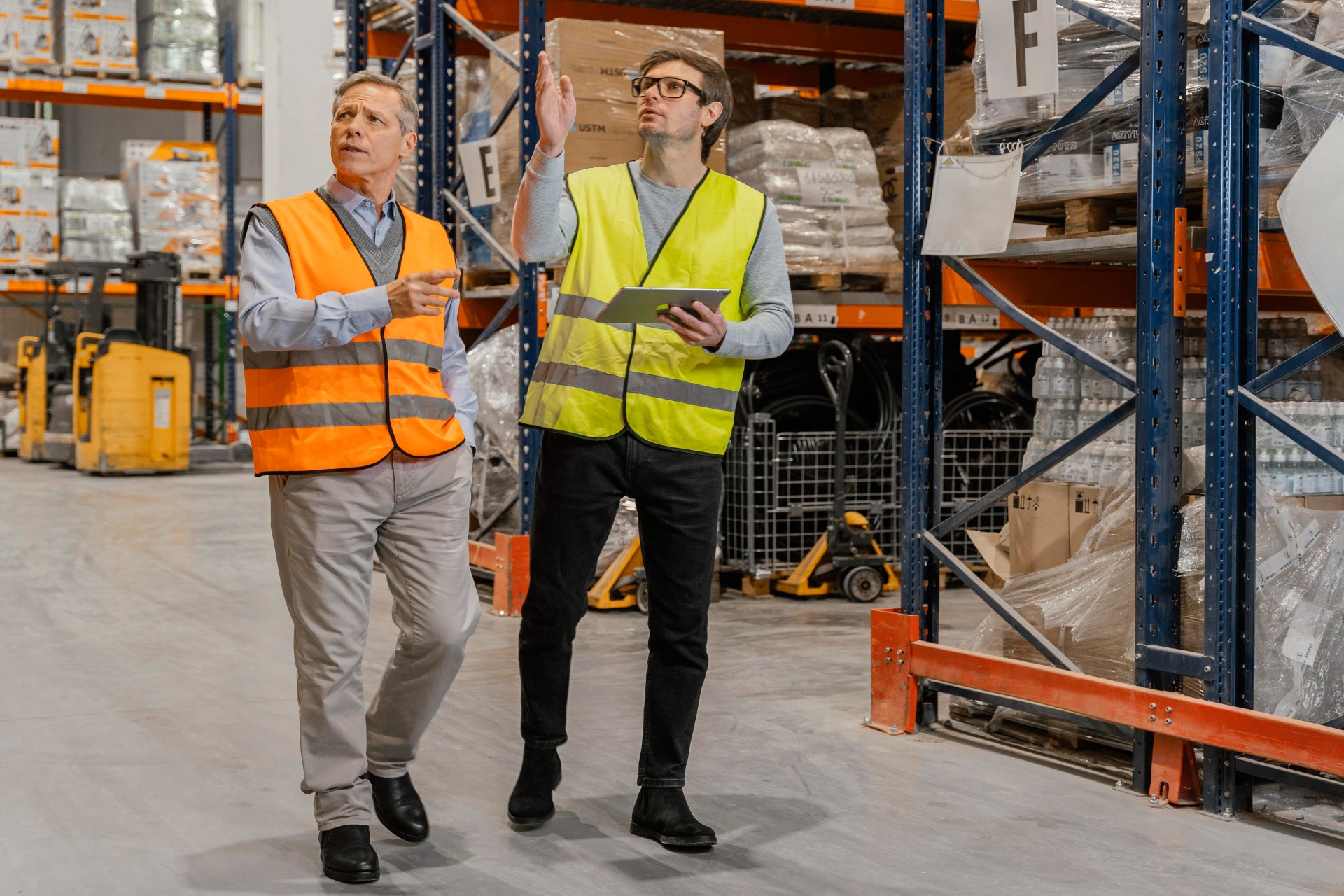 Warehouse workers coordinating inventory management and overseeing automated fulfillment systems