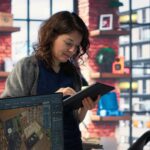 E-commerce manager using AI-driven demand sensing software to forecast inventory needs