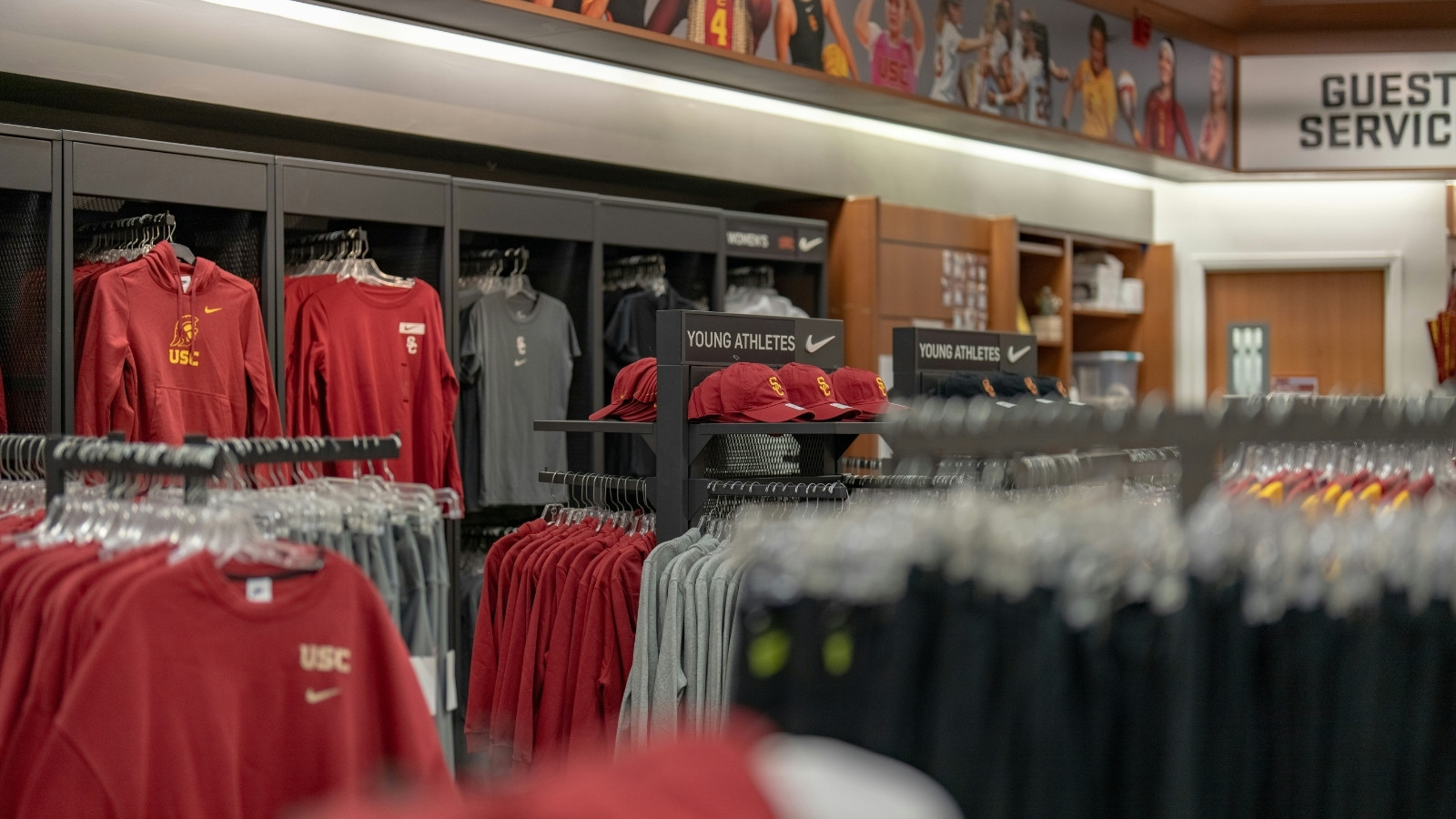 Interior of a sports retail store displaying hoodies, caps, and athletic apparel organized on racks and shelves.
