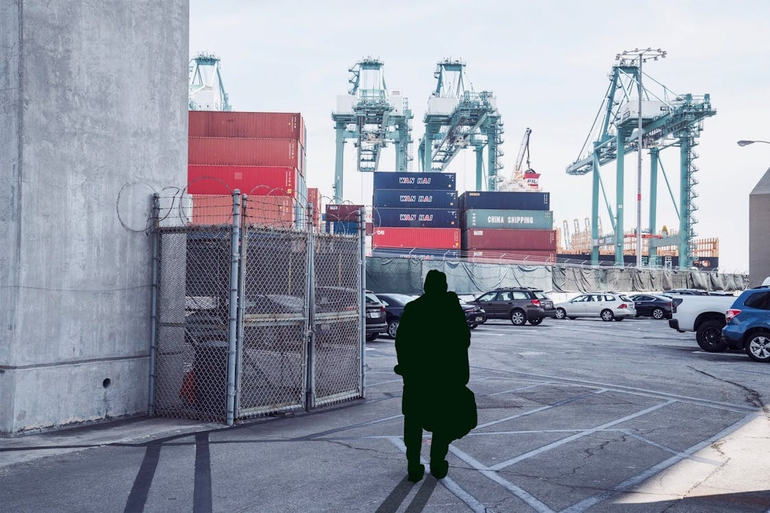 A person watching containers and cranes