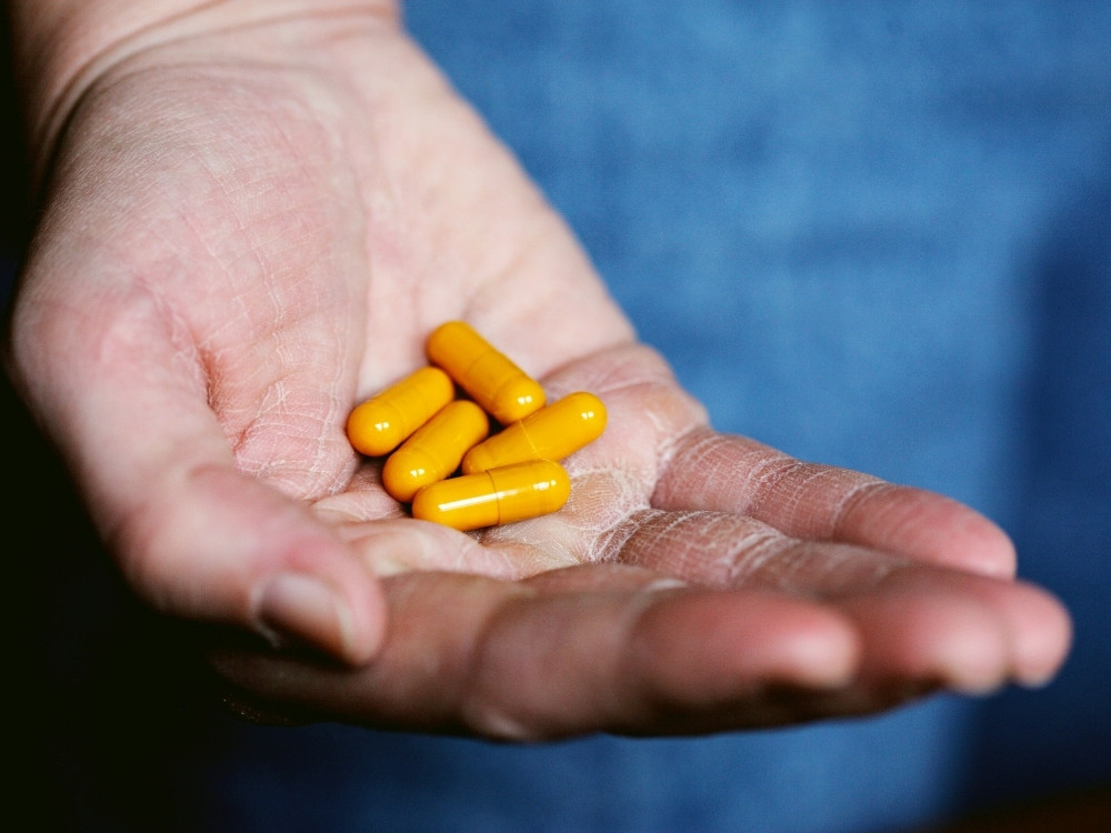 Dietary supplement capsules in hand representing consumer safety in Europe.