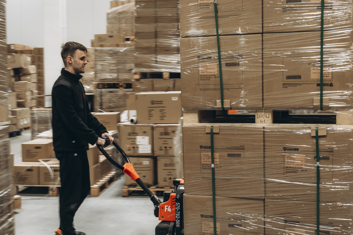 FLEX warehouse team member moving palletised stock in a fulfilment centre