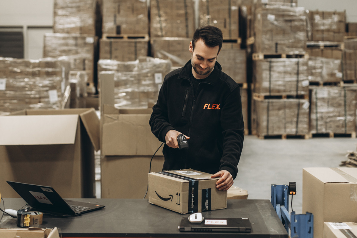 Operator magazynu skanujący karton podczas procesu fulfillmentu