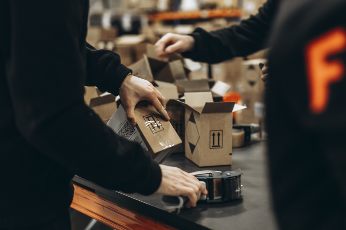 FLEX warehouse team member packing a customer order at a fulfilment station