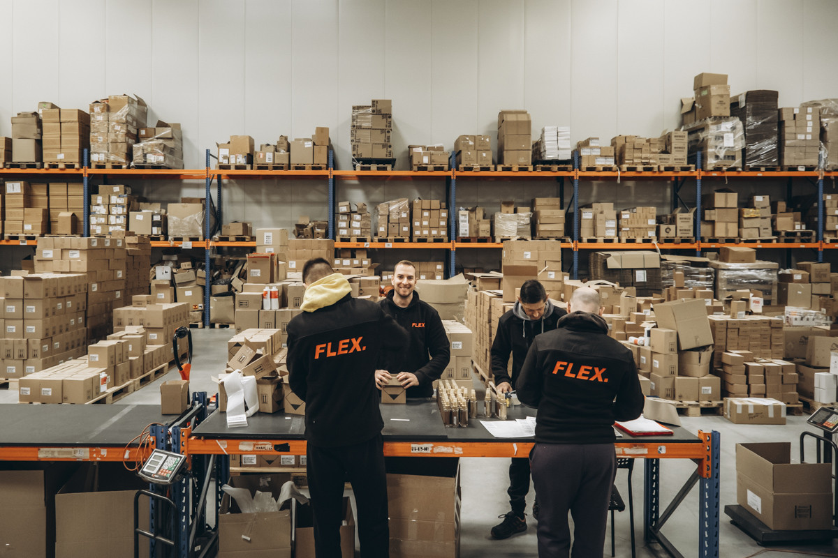 FLEX warehouse team processing multiple orders at packing stations